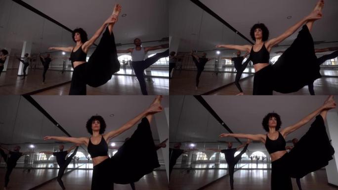 在工作室进行舞蹈排练时，舞者伸展腿
