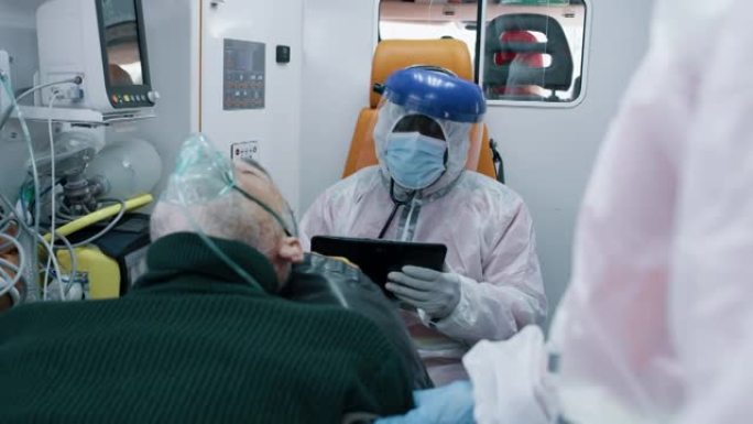 护理人员在冠状病毒患者附近使用平板电脑