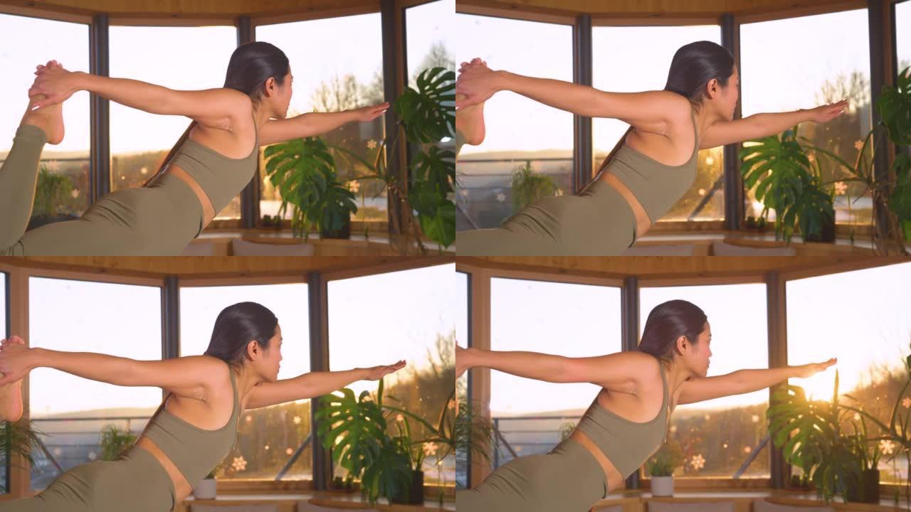 慢动作，特写: 在日落灯光下跳舞的湿婆姿势的运动型亚洲女士