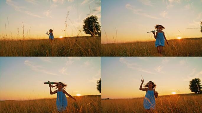 日落时分，SLO MO女孩在草地上玩飞机玩具