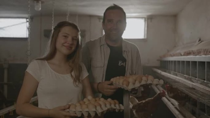 SLO MO的父亲和女儿在鸡舍里手里拿着新鲜鸡蛋时摆姿势