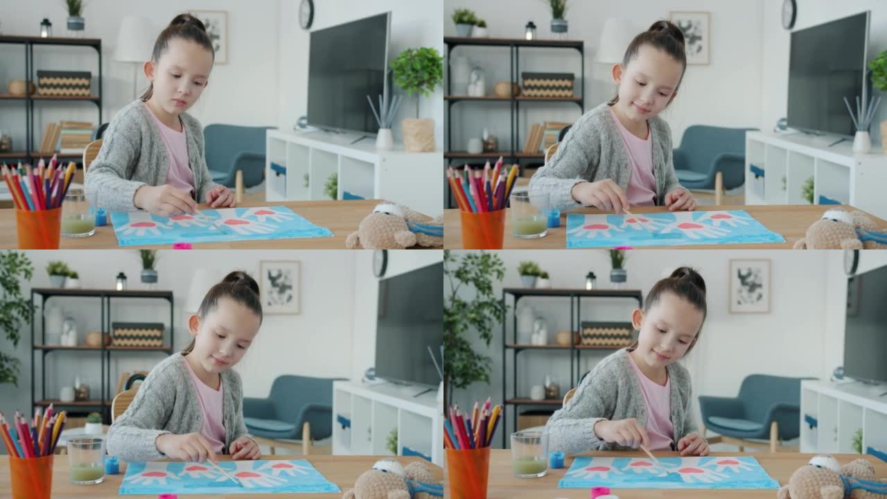 创意小女孩肖像画手的照片，心坐在家里的桌子上