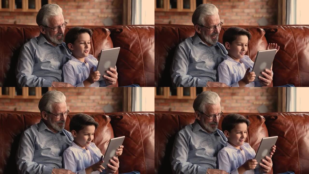 60多岁的老人与孙子一起使用数字计算机平板电脑。