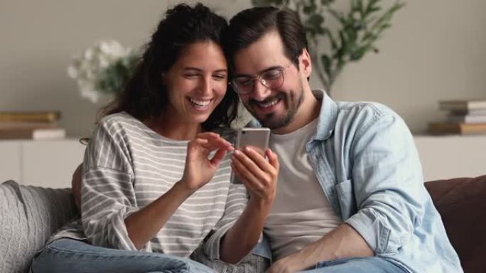 幸福的结合家庭夫妇使用智能手机应用程序。