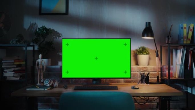 台式电脑显示器，模拟绿屏站在木桌上，具有高度可调功能。现代客厅或带砖墙的创意阁楼办公室的家里色键显示