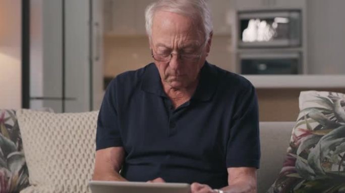 一名高级男子在家中使用平板电脑的4k视频片段