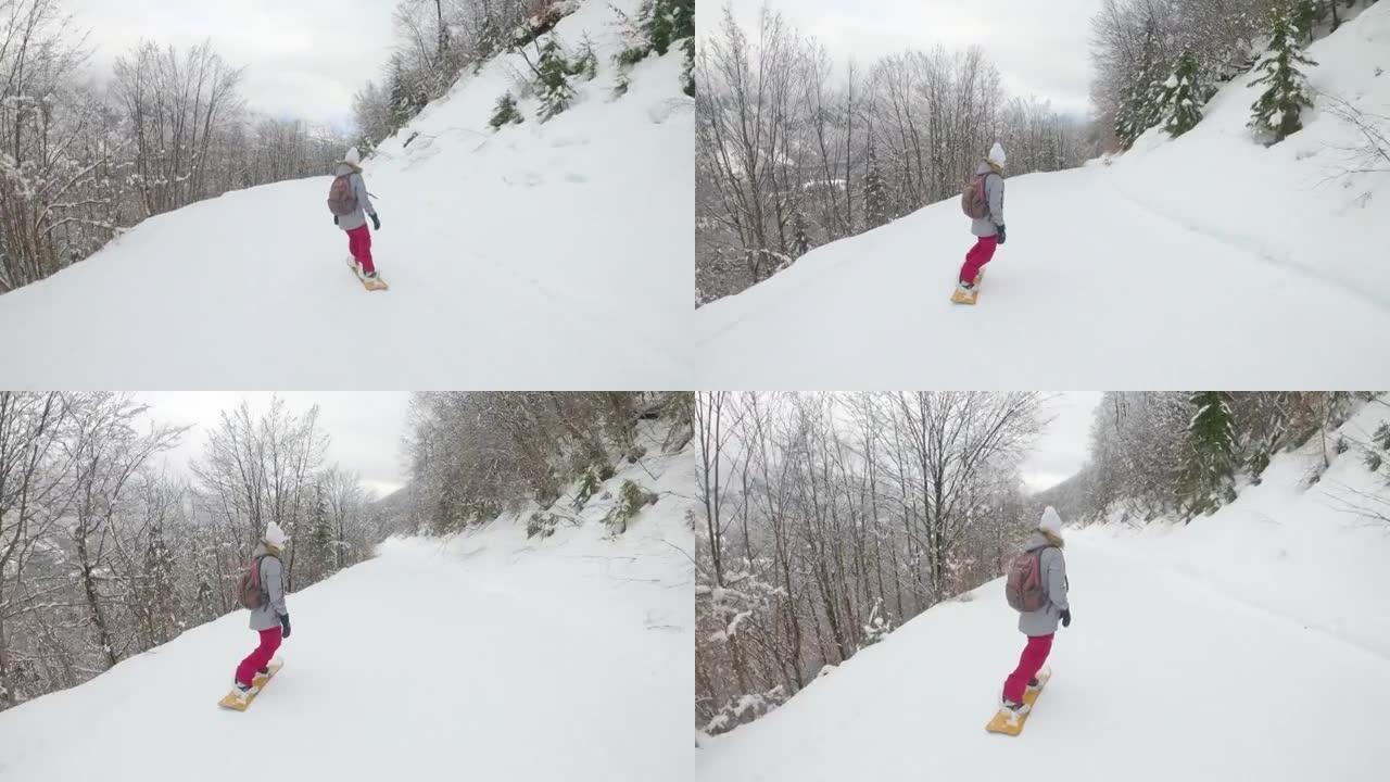 无法辨认的女子滑雪板沿着滑雪场斜坡穿过森林。