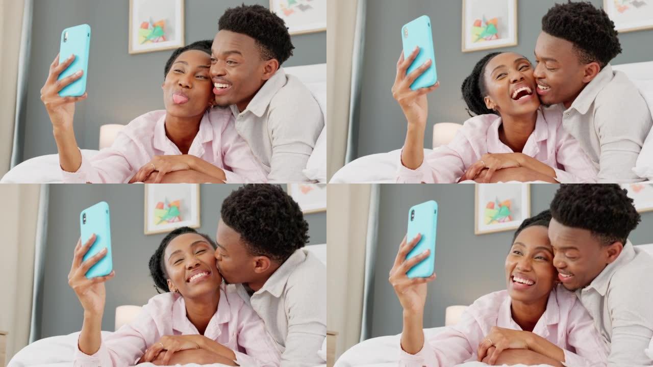智能手机上的情侣自拍，黑人妇女亲吻非洲男子顽皮的爱，并在家庭卧室放松。移动技术互联网，有趣的早晨微笑