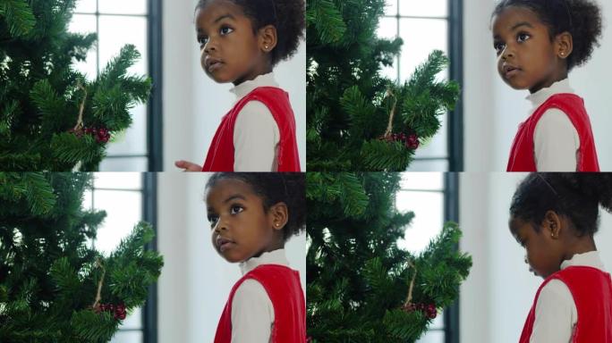 幸福的肖像给女孩非洲民族年龄3岁的威林红色服装准备和装饰圣诞树。圣诞精神概念。