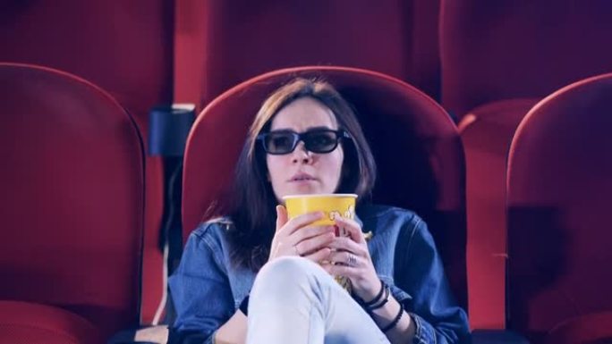 一位女士在电影院看电影时感到害怕