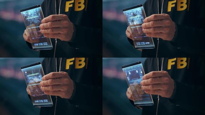联邦调查局特工手中的一个未来的HUD小型屏幕在模糊的背景上的特写