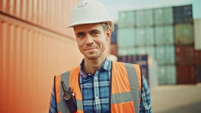 一个穿着白色安全帽、橙色高能见度背心、方格衬衫和工作手套的英俊高加索工业工程师的微笑肖像。集装箱码头