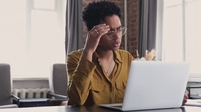 在笔记本电脑上工作的非洲妇女感到紧张