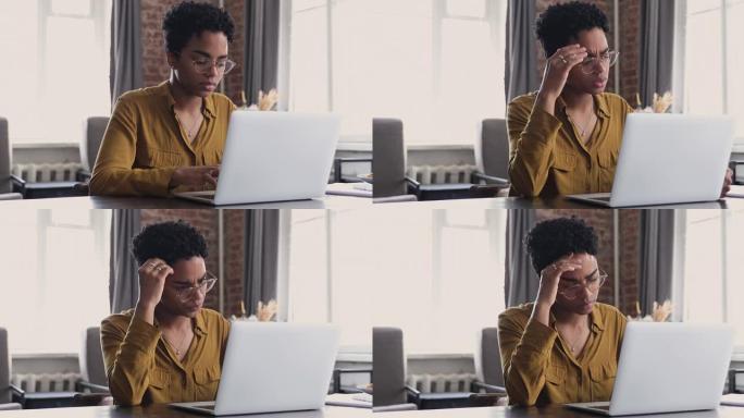 在笔记本电脑上工作的非洲妇女感到紧张