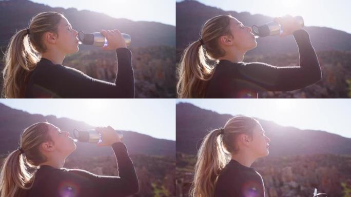 一名年轻女子在山上喝水的4k录像