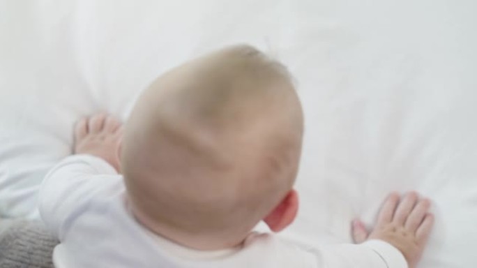 一个婴儿在家里的床上爬行的4k视频片段