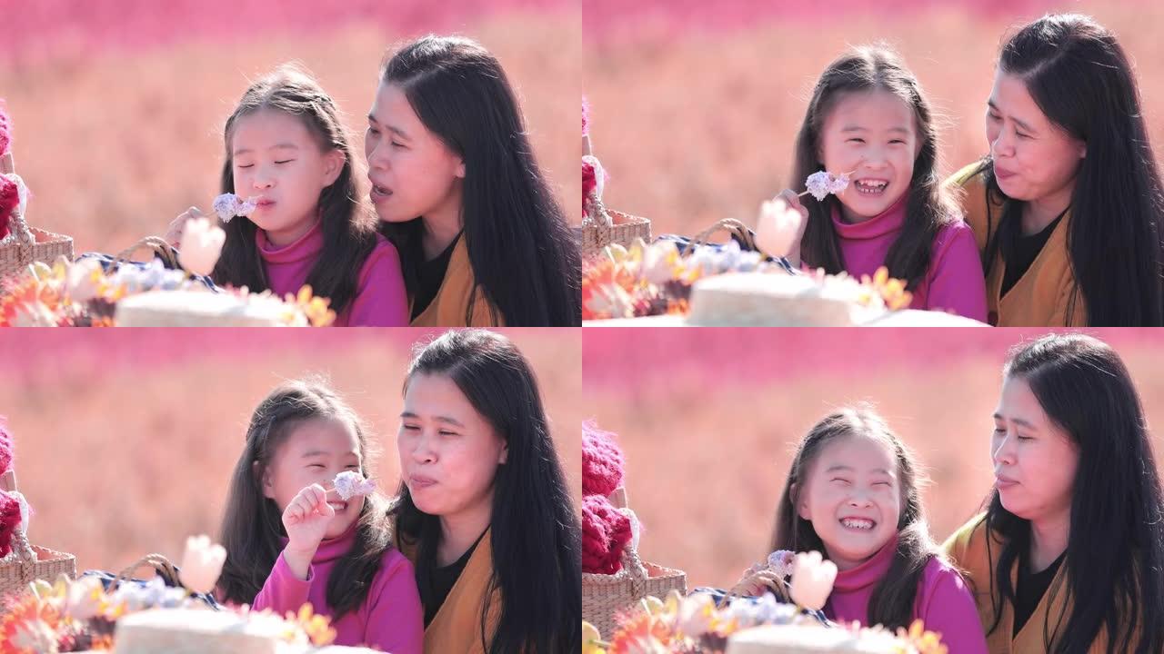 SLO MO美丽的小女孩和她的母亲在户外公园吃零食