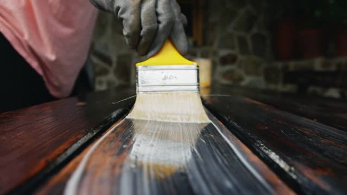 SLO MO女人油漆户外家具的木质表面
