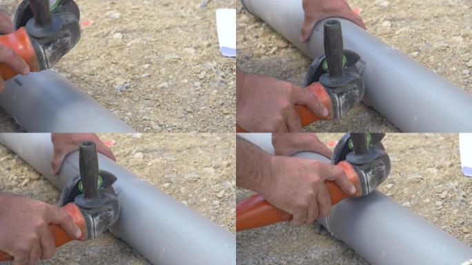 特写: 面目全非的水管工使用角磨机切割pvc污水管。