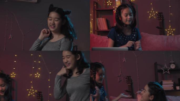 迷人的亚洲小女孩在笔记本电脑屏幕前跳舞，通过视频通话与她的朋友聚会。三个兄弟姐妹在客厅用vdo会议技