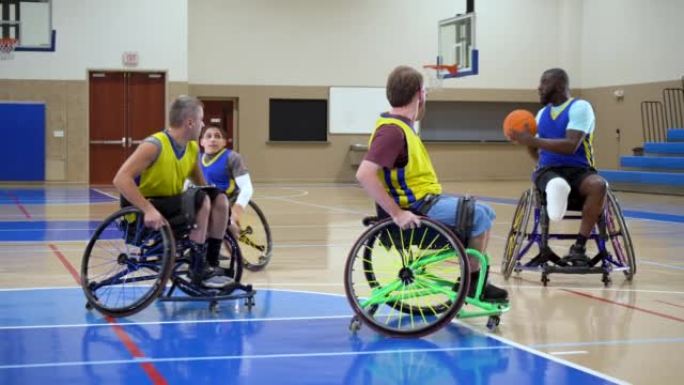 四名男子打轮椅篮球，传球