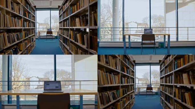 SLO MO笔记本电脑在图书馆书籍过道尽头的桌子上