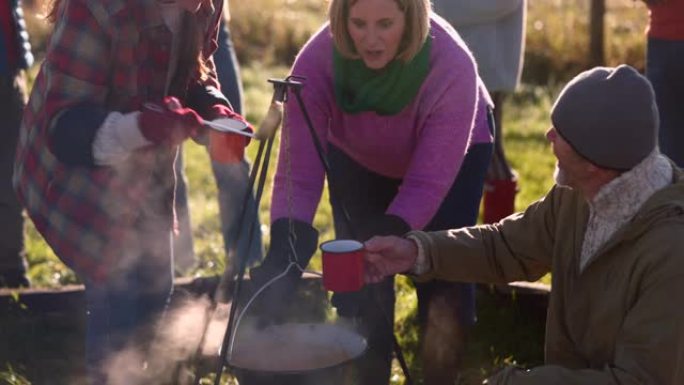 篝火旁的志愿者外国人农场野餐野炊喝汤保暖