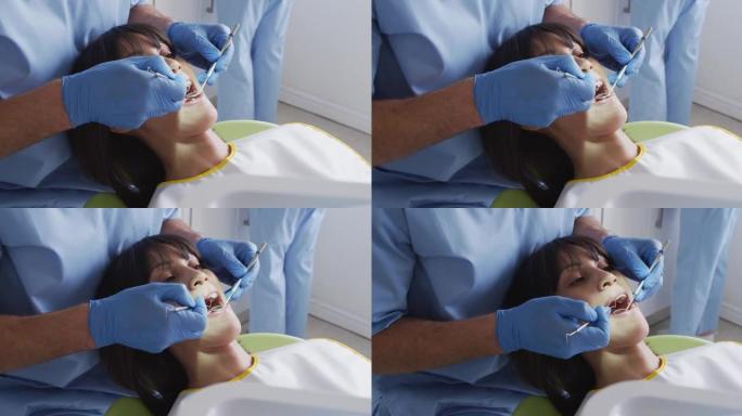 高加索男性牙医和牙科护士在现代牙科诊所检查女性患者的牙齿
