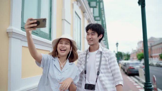 亚洲夫妇在旅行时在智能手机上自拍