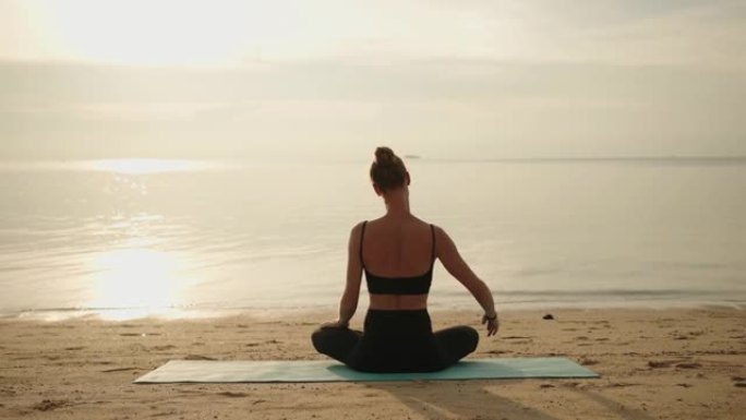 女人为瑜伽热身海边瑜伽背影视频素材