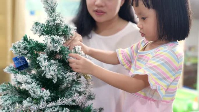 4K UHD手持年轻亚洲女孩装饰圣诞装饰品，妈妈为节日快乐做准备。