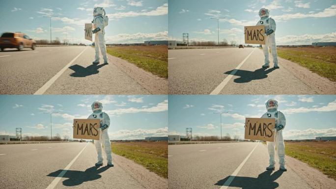 穿着宇航服的人站在路边，举着上面写着火星的标志。宇航员想搭便车。太空人穿着未来主义的西装，手上有技术