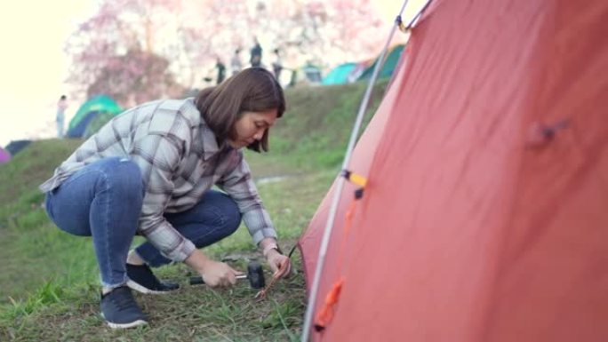 女人在露营区搭起帐篷和露营地