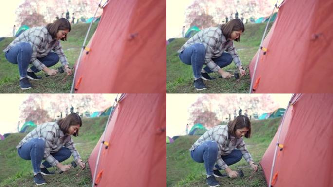 女人在露营区搭起帐篷和露营地