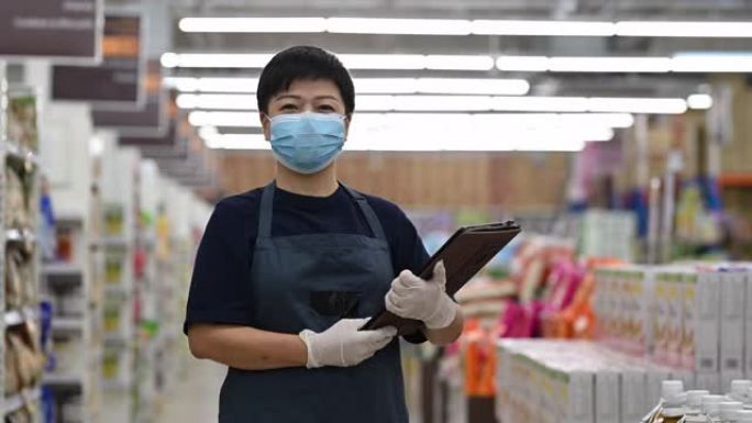 一个亚洲华人超市中年妇女店主零售助理与口罩