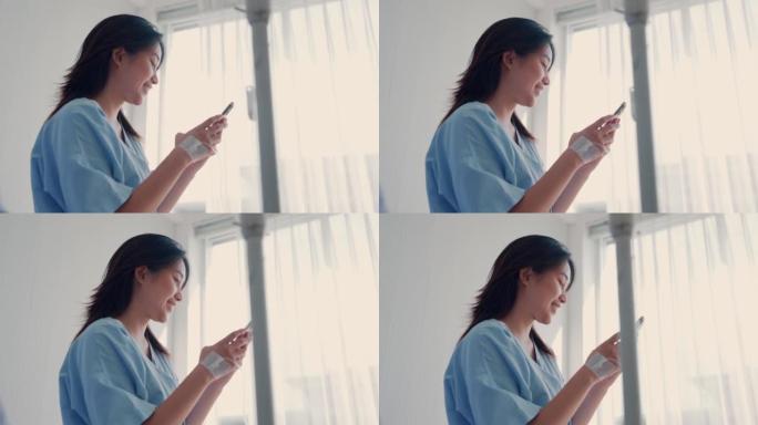 年轻女子在医院的病床上使用智能手机。