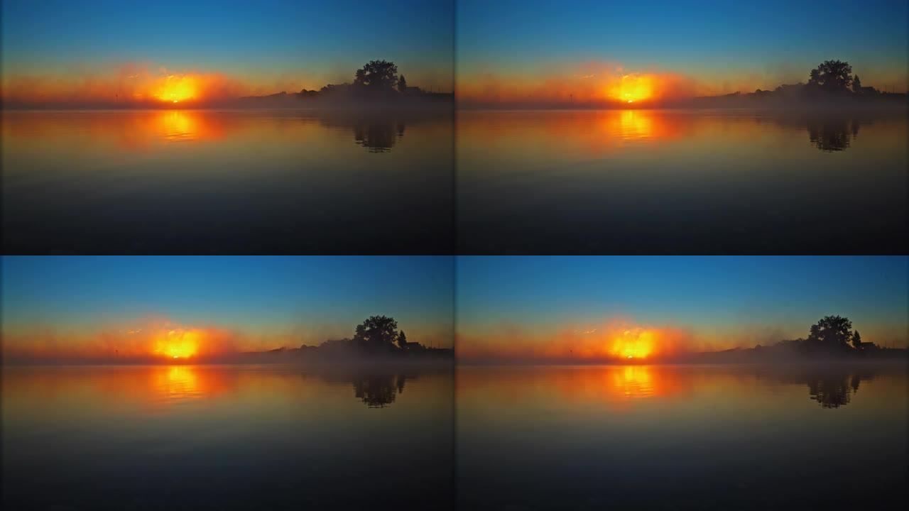 在雾蒙蒙，宁静的湖面上雄伟的日出