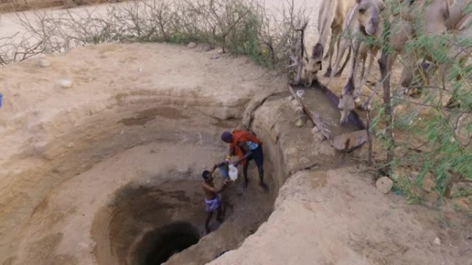 气候变化。干旱。水危机。由于持续干旱，Close-up.African人从非常深的井里为骆驼取水。肯