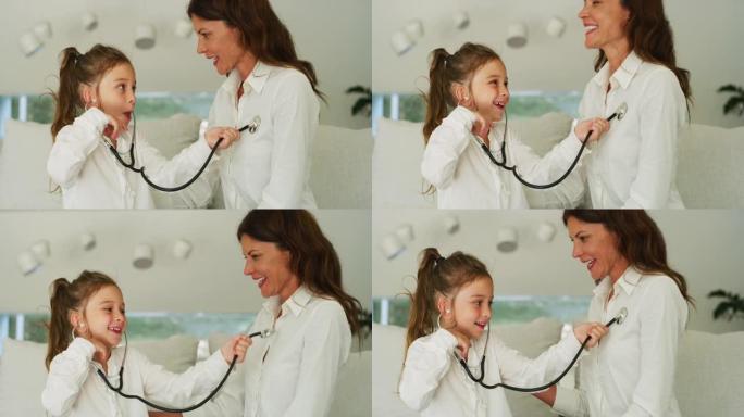 一个快乐微笑的小女孩的真实镜头正在沙发上与母亲扮演医生