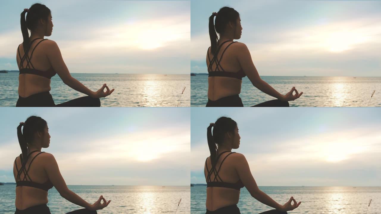 迷人的年轻健康的女人瑜伽运动在海滩上