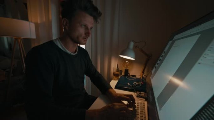 男人在家庭办公室的电脑上写字