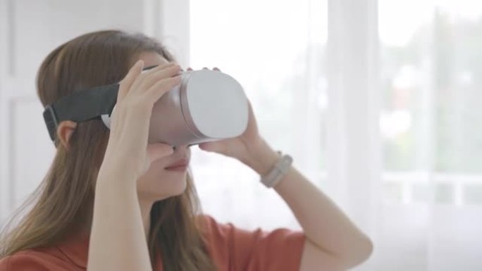 特写，36岁的美丽亚洲年轻女商人站在家庭办公室，戴着虚拟现实护目镜，使用虚拟现实耳机进行远程工作。成