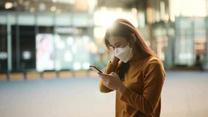 女人在病毒休息时使用智能手机waring口罩