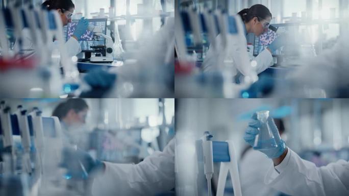 医学研究实验室: 护目镜的女科学家在显微镜下看，第二位科学家拿着带有生化物质的玻璃器皿。先进的医学科
