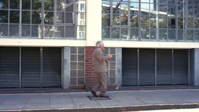 4k视频片段，一名高级男子在城市背景下跳舞