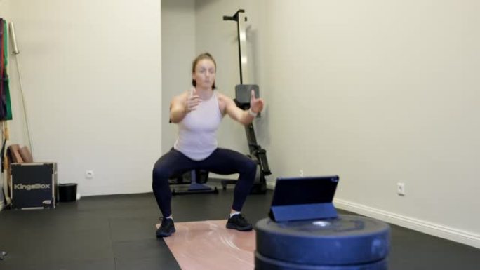 健身教练在数字平板电脑上进行在线锻炼课程