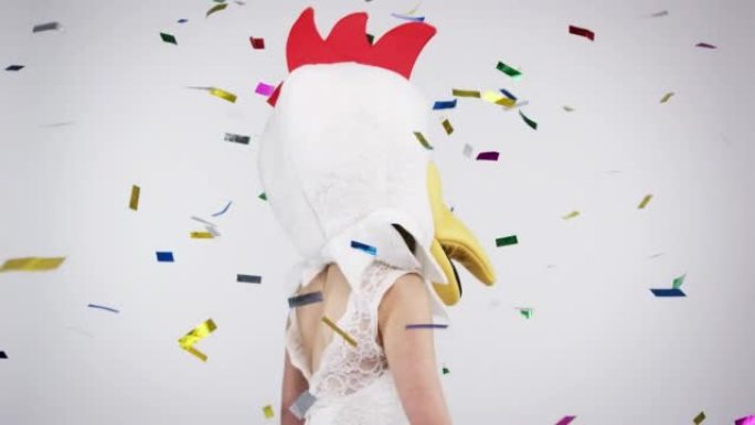 4k视频片段，一名女子戴着鸡头在演播室背景下跳舞