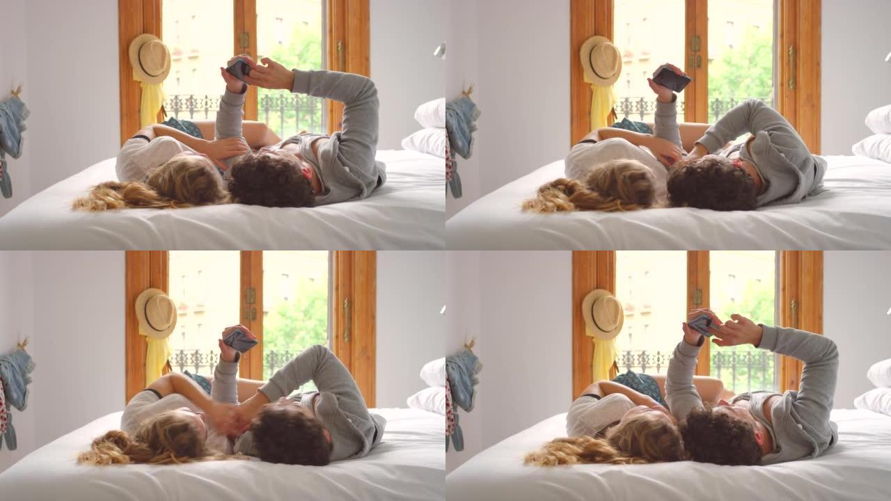 一对年轻夫妇在床上放松时使用智能手机的4k视频片段