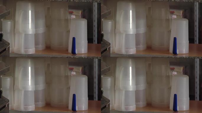 在学校食堂的厨房内堆放塑料杯和瓶子。特写。