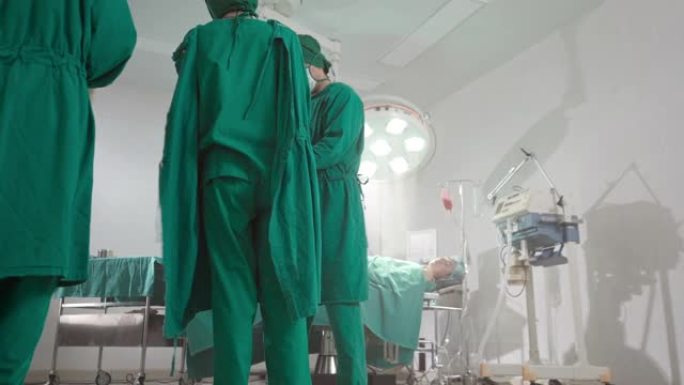 4K UHD多莉离开: 外科医生在手术前穿上手术擦洗布和手术手套。医院医疗保健概念。